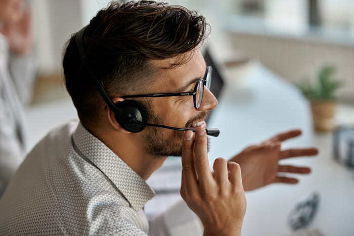 happy-call-center-agent-usando-auriculares-mientras-habla-con-clientes-trabajando-en-oficina (1) (1)