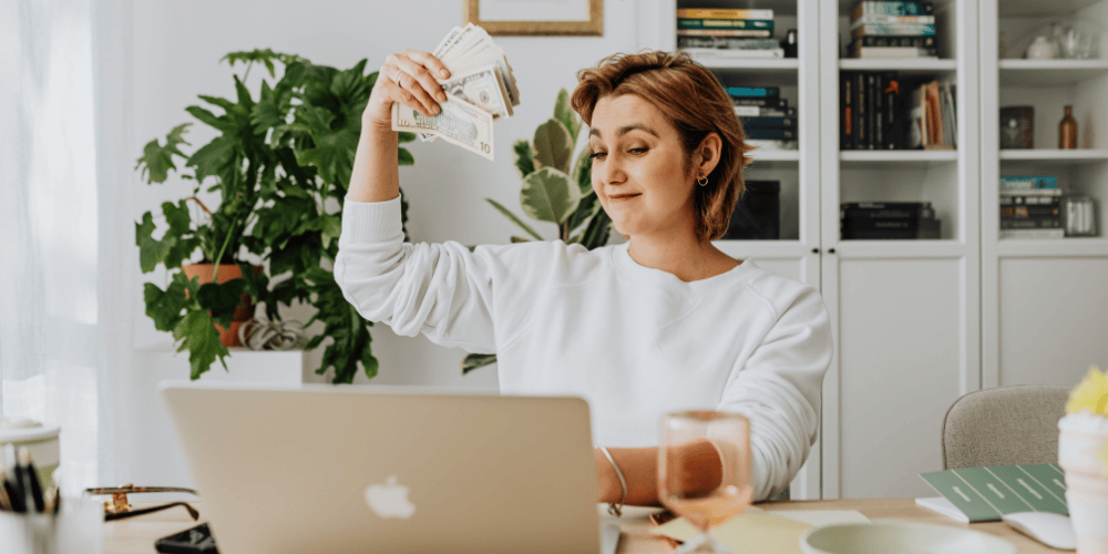 Femme devant ordinateur avec des billets